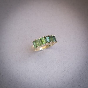 Emerald cut ombre green tourmaline half eternity ring set in yellow gold
