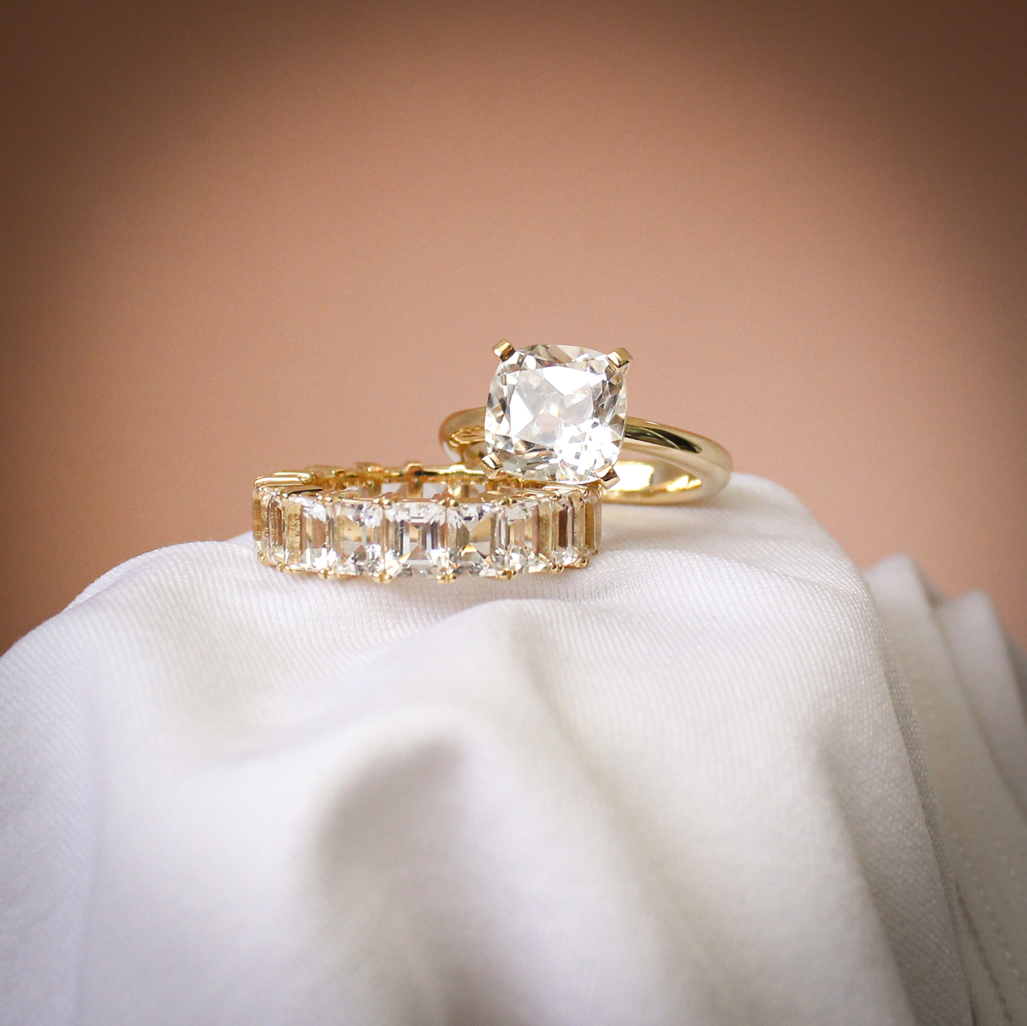 Cushion cut quartz engagement style ring with emerald cut quartz full eternity band in 9k yellow gold