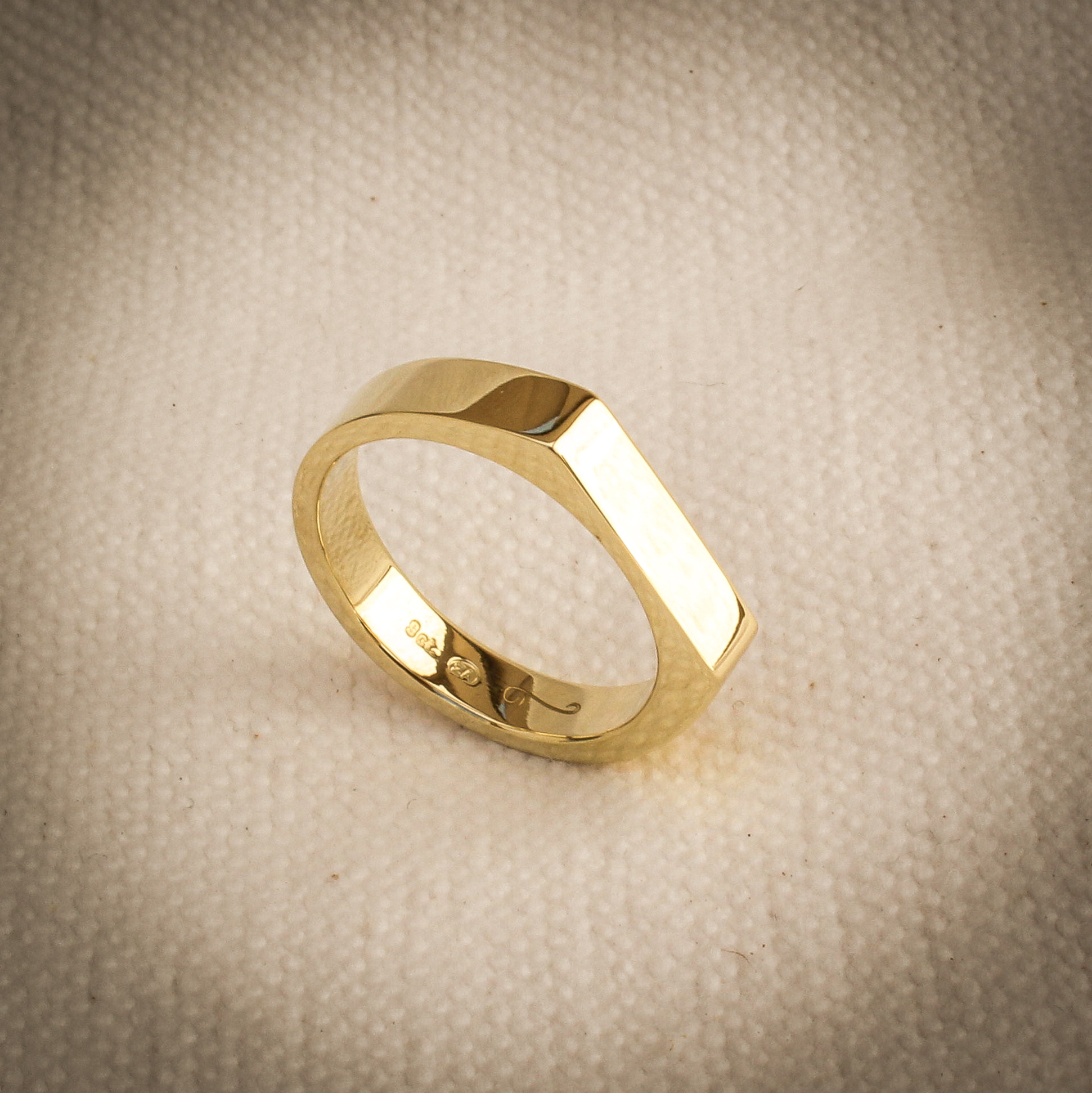 Men’s 9k yellow gold signet ring with polished face and hidden diamond detail inside the band