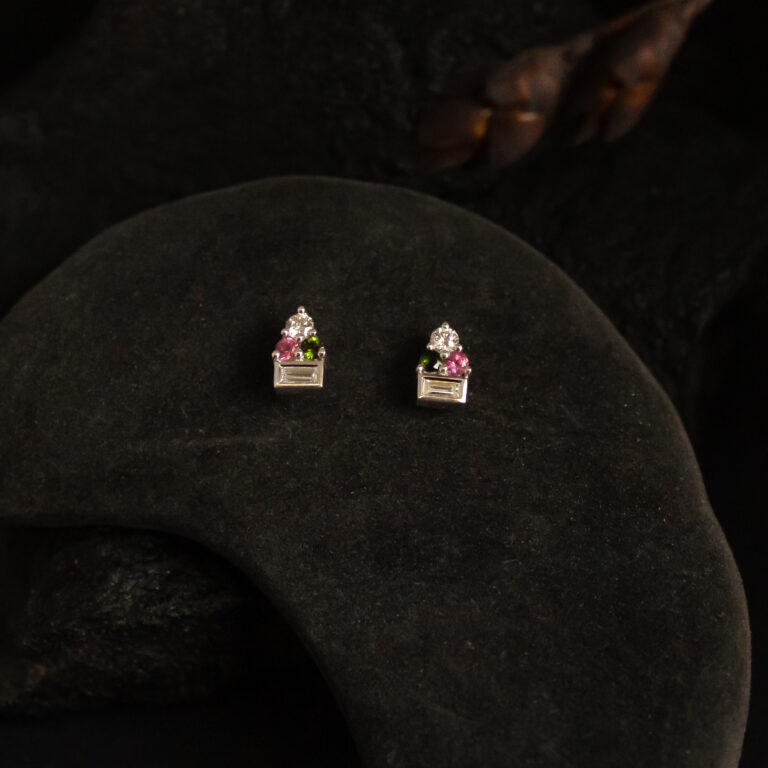 Silver stud earrings set with diamonds and pink and green tourmalines in a delicate cluster design