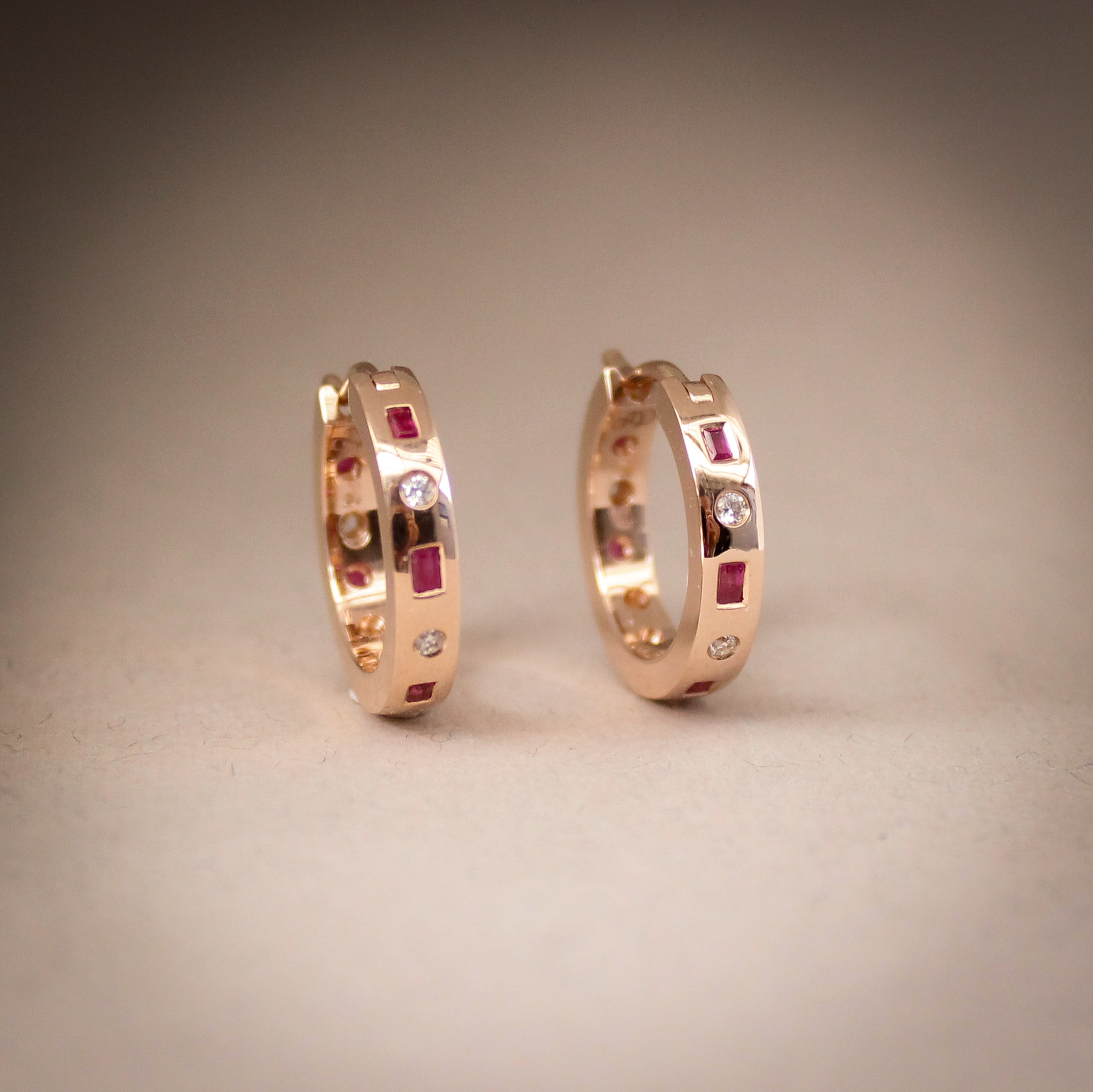 9k rose gold hoop earrings set with baguette rubies and round diamonds in a matching set design