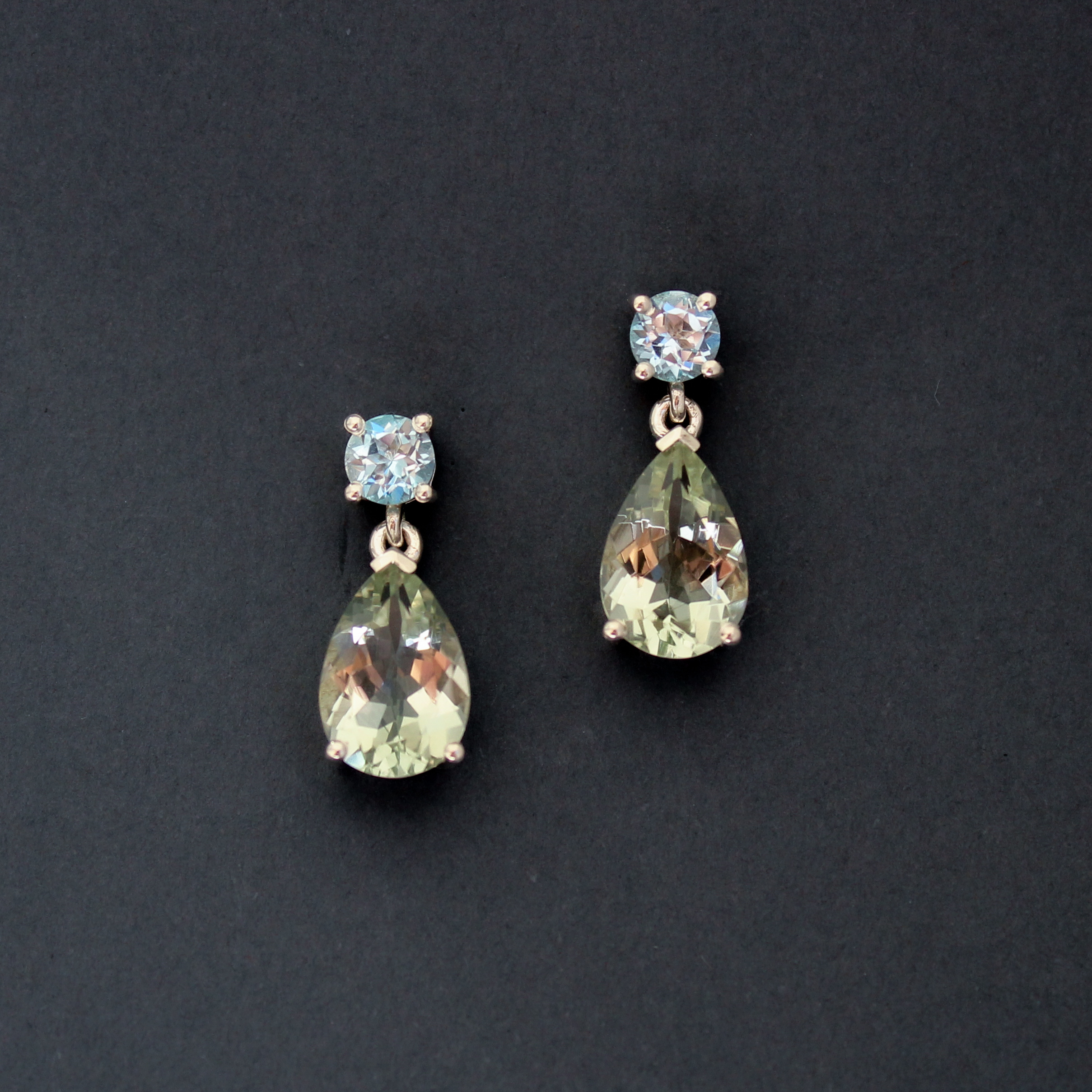 Silver drop earrings set with pear-shaped prasiolite and round blue topaz gemstones