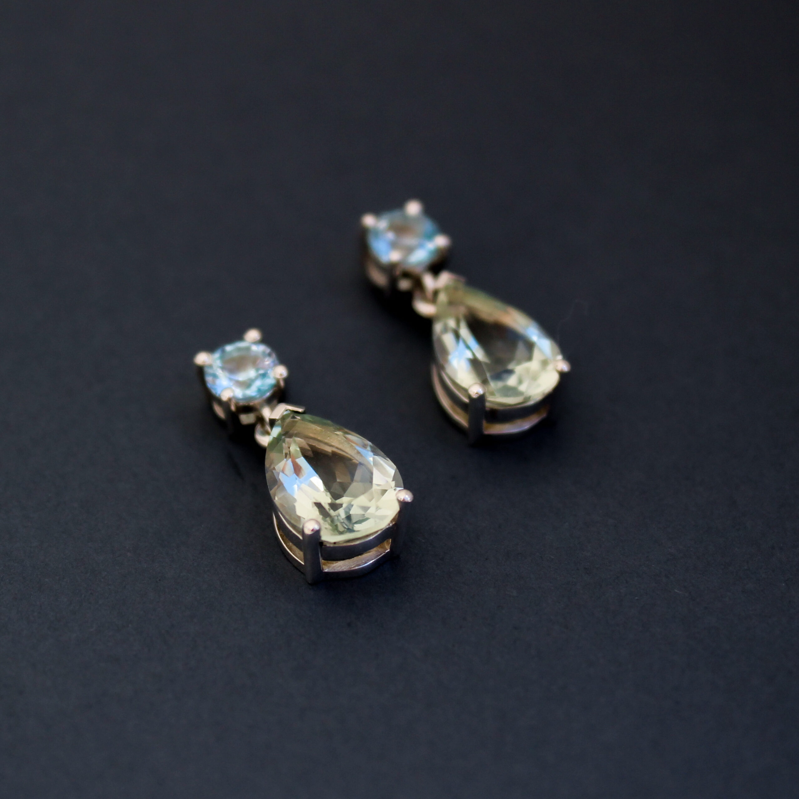 Silver drop earrings set with pear-shaped prasiolite and round blue topaz gemstones