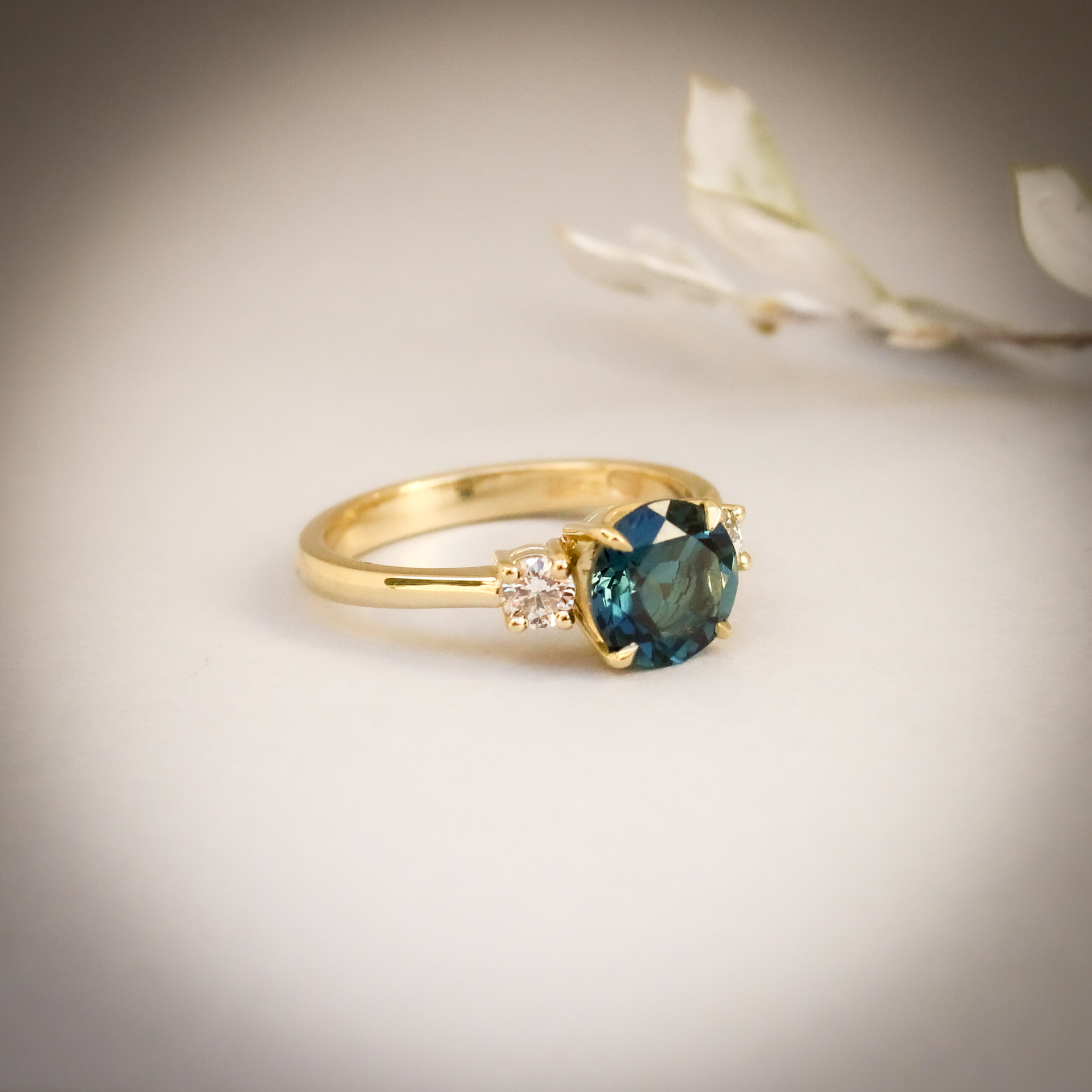9k yellow gold engagement ring with round London blue topaz centre stone and two round diamonds