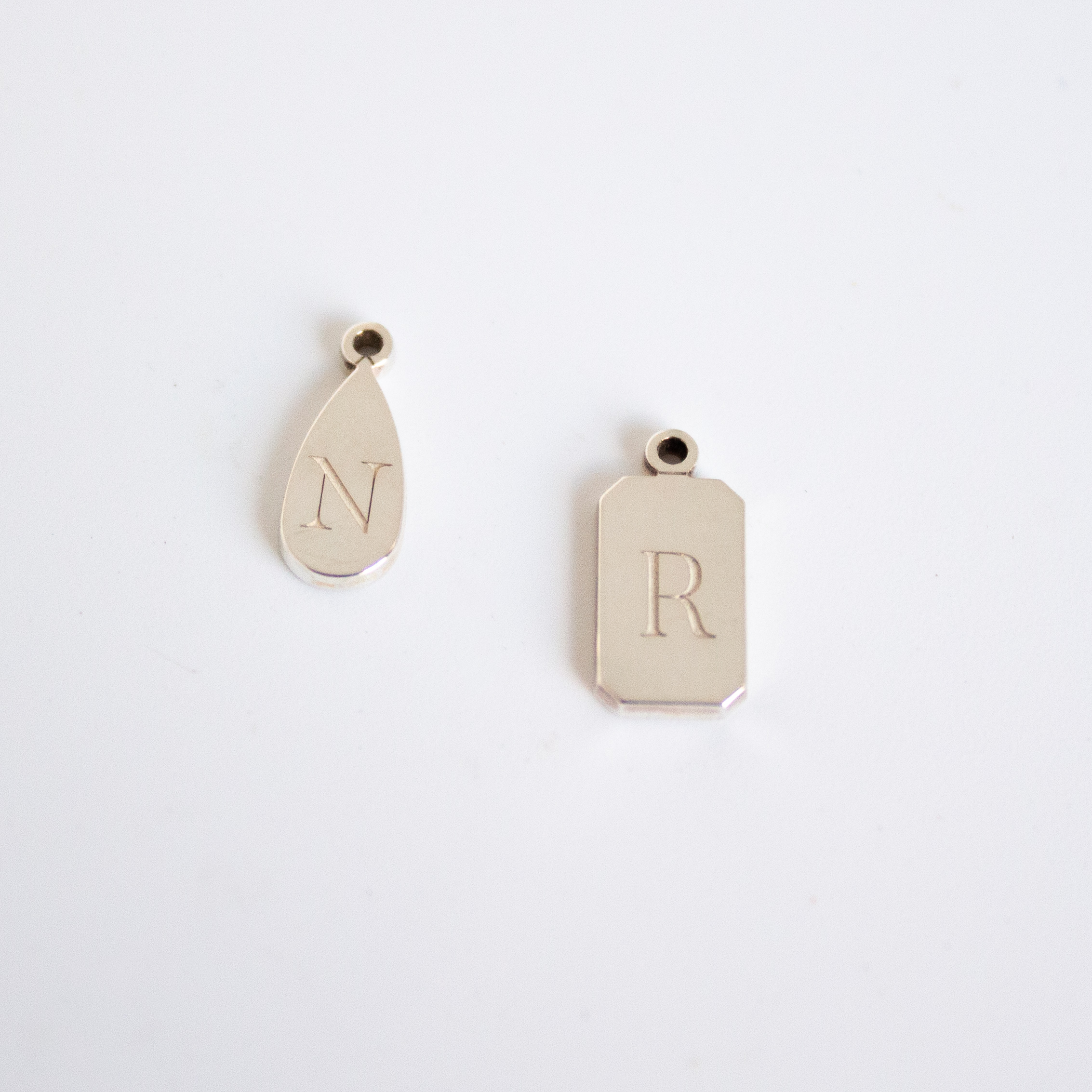 Personalised emerald shape initial tag necklace in gold with custom engraved initial and gemstone detail by Tyldesley Jewellers